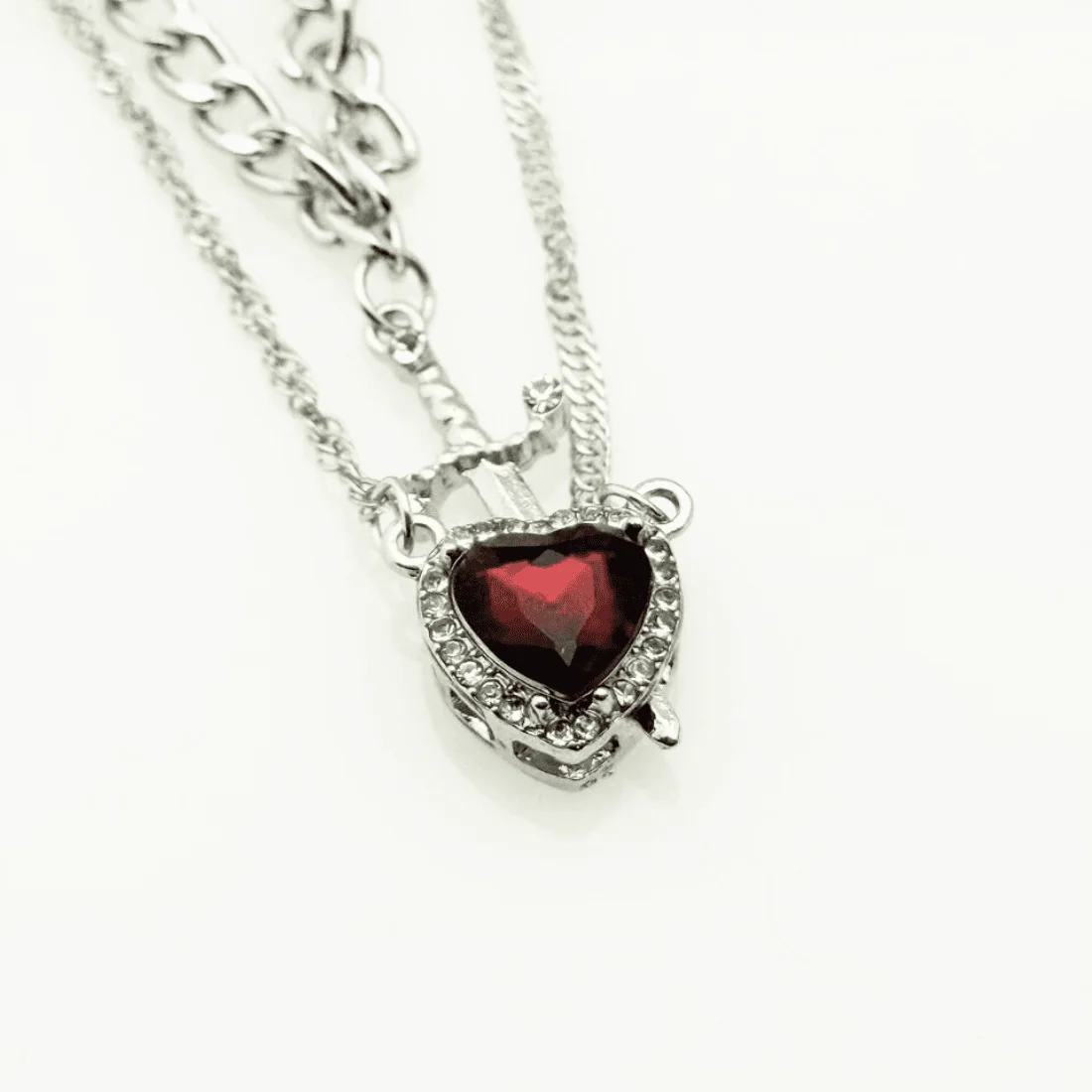 Кулон у формі серця з червоним каменем та інкрустацією кристалами.