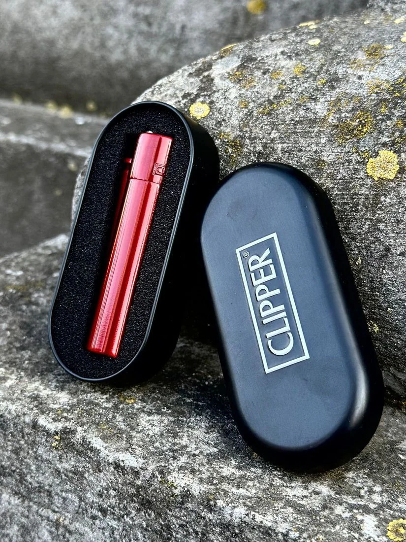 Запальничка Clipper Metall Red Devil у подарунковій коробці на камені, на природі