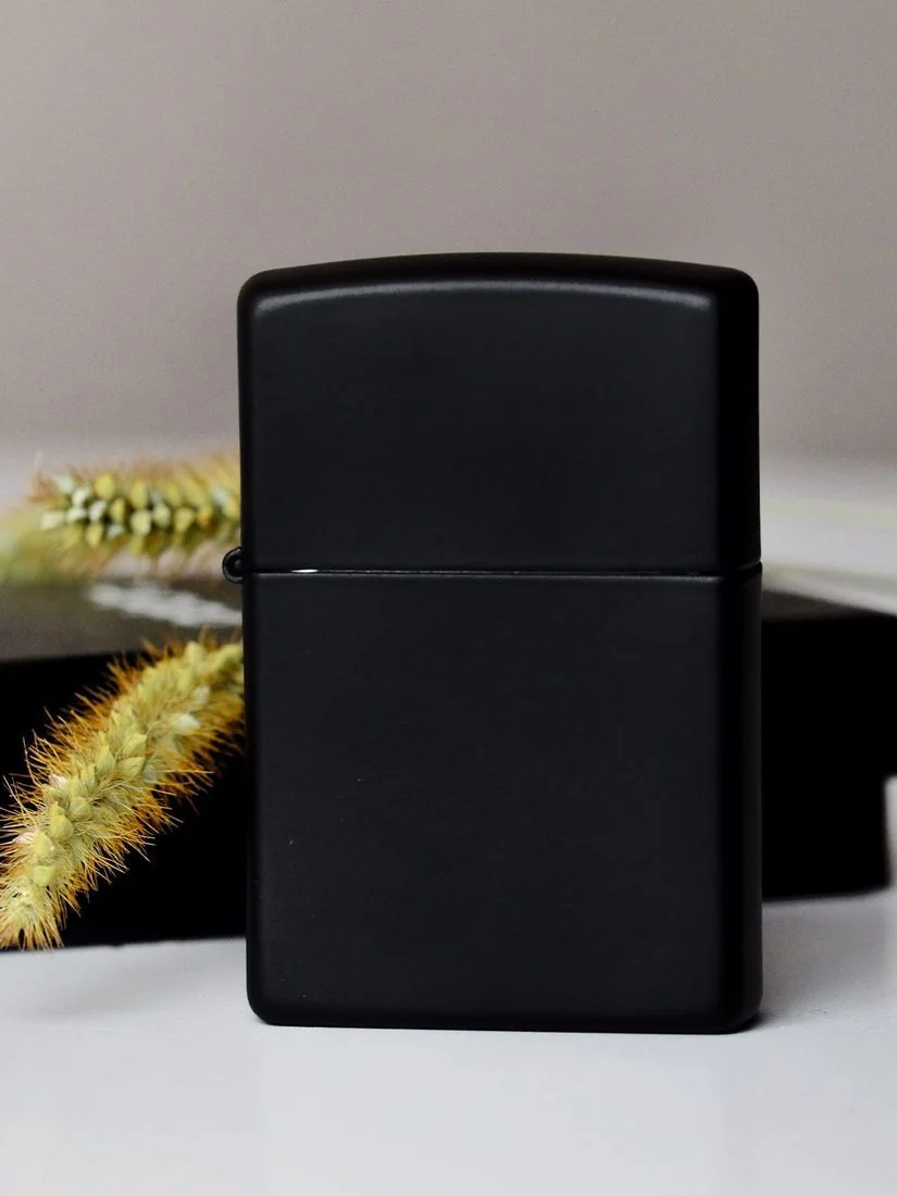 Класична запальничка Zippo Black Matte на фоні декоративних елементів